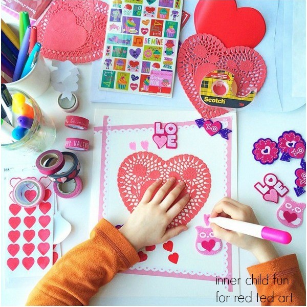 A pair of young hands makes a valentine's day card with crafting supplies