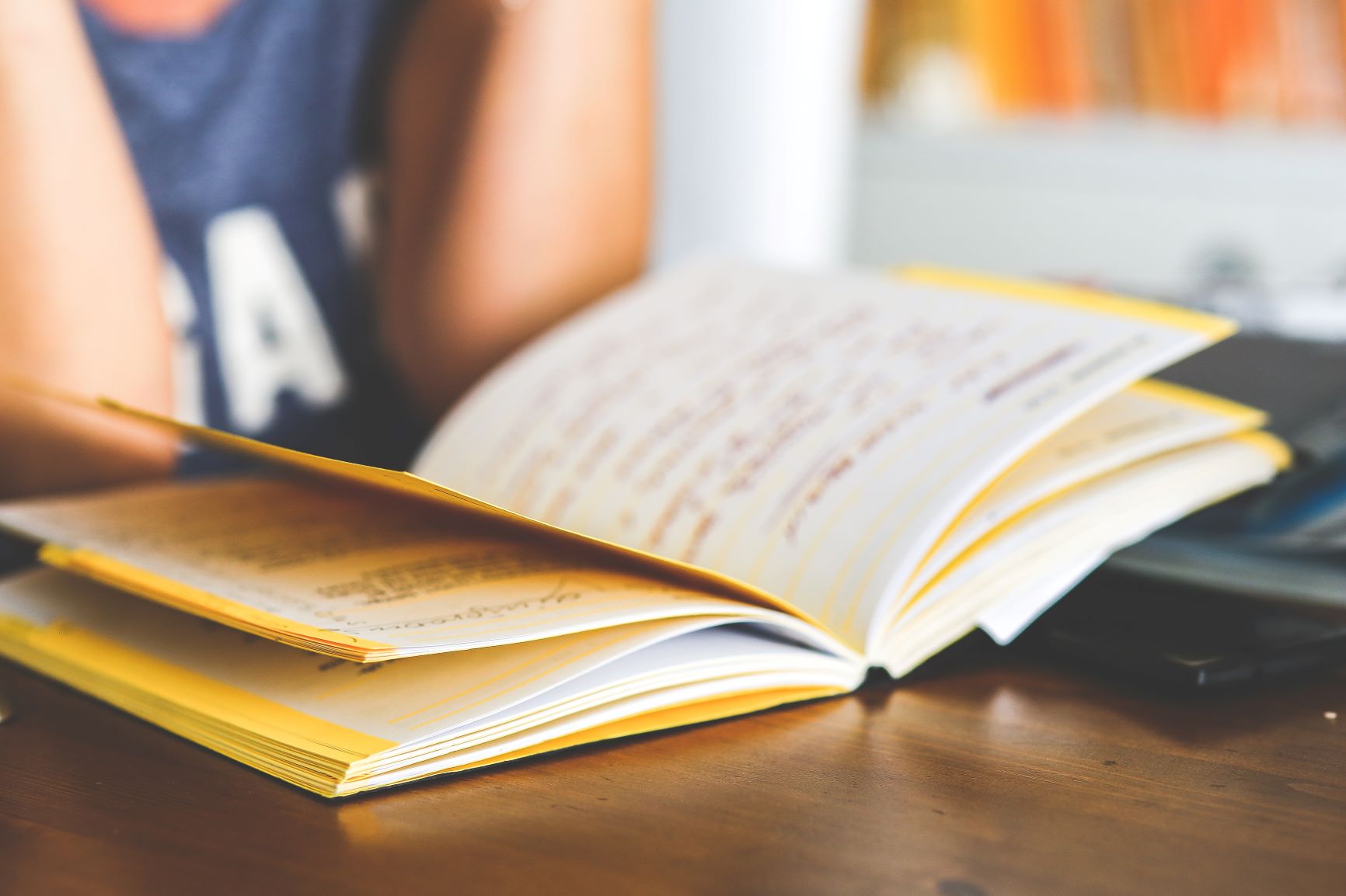 A woman reads from a yellow notebook