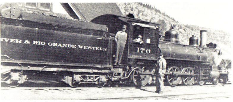 Black and white image of men standing next to a train