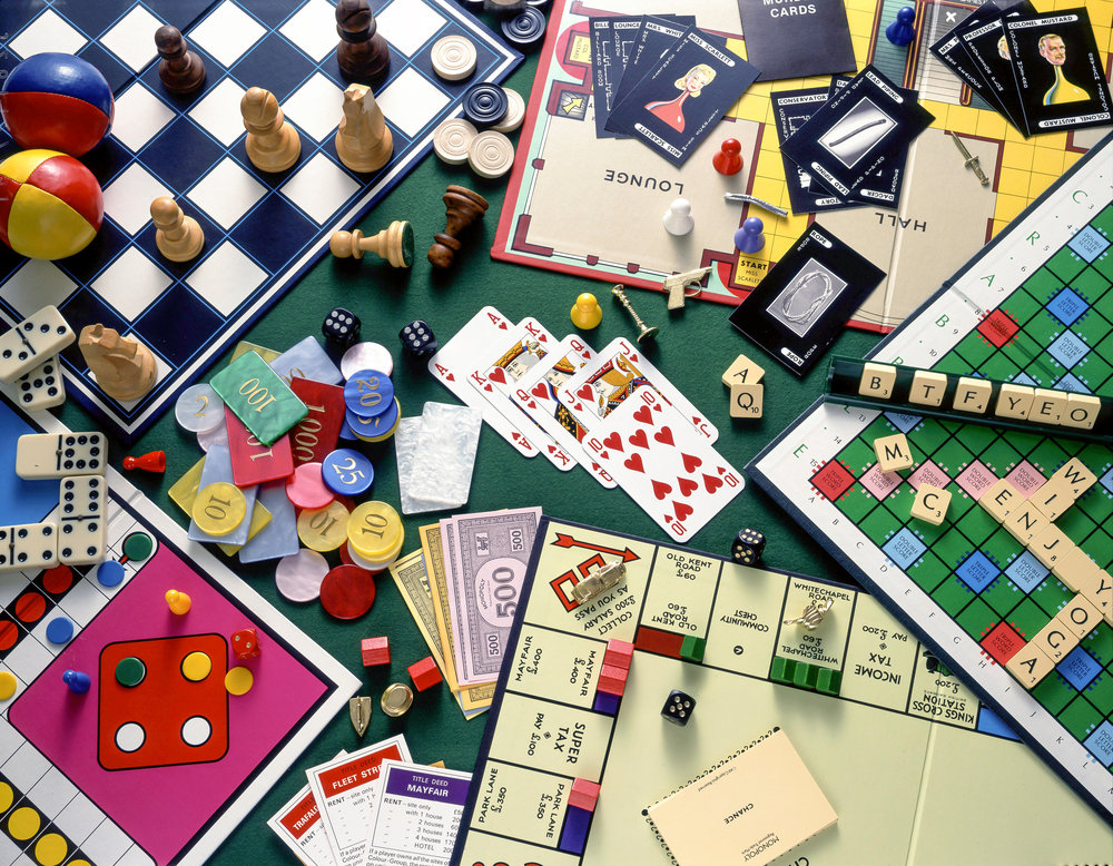 Still-life selection of board games (Monopoly, Chess, Cluedo, Scrabble) with playing cards and gambling chips